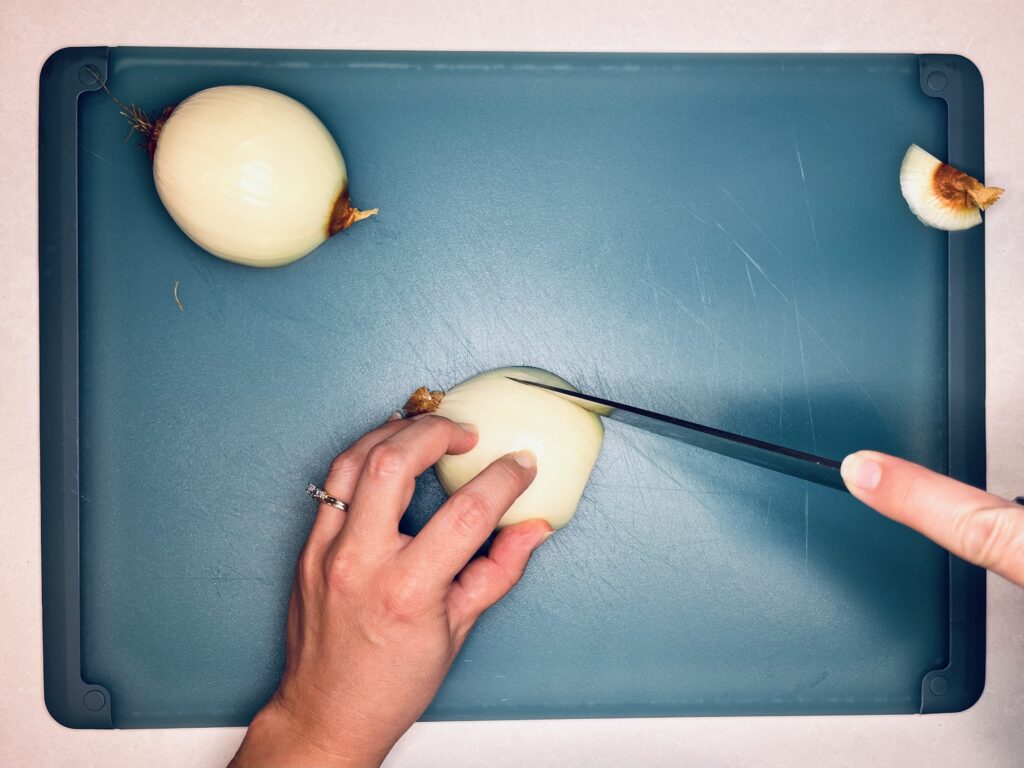 A knife making slices in an onion