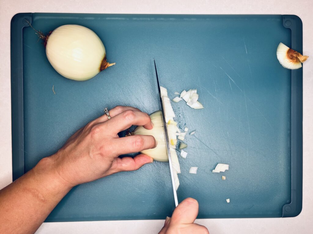 a knife continuing to slice an onion