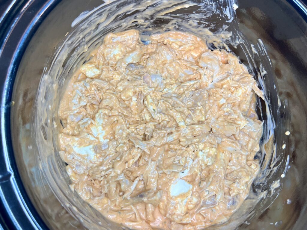 cream cheese, buffalo sauce, ranch dressing and chicken stirred together in a slow cooker