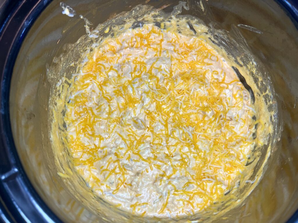 shredded cheese sprinkled over slow cooker contents