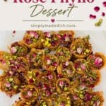This image features a tray of pistachio rose phyllo dessert, a visually appealing and aromatic pastry made with crispy phyllo layers, filled with pistachios, and garnished with rose petals and chopped pistachios. The vibrant pink and green toppings highlight the dessert's floral and nutty flavors, making it an inviting image for anyone interested in Middle Eastern desserts or pistachio-based sweets.