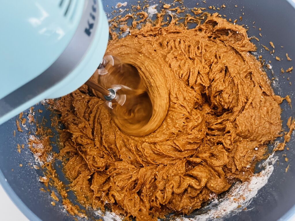 Combining cake mix, eggs and pumpkin with an electric hand mixer.