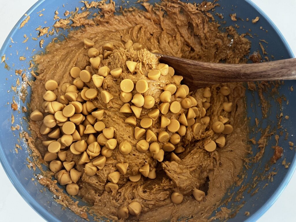 using a wooden spoon fold in butterscotch chips.
