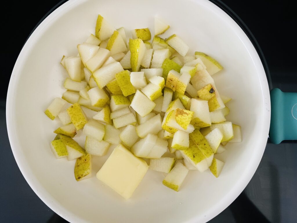 Butter and chopped pears in a sauce pan on the stove.