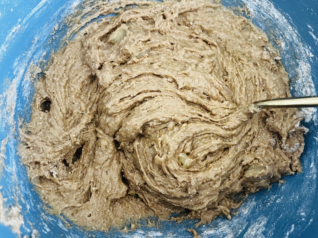 Mixed apple spiced donut batter in a mixing bowl.