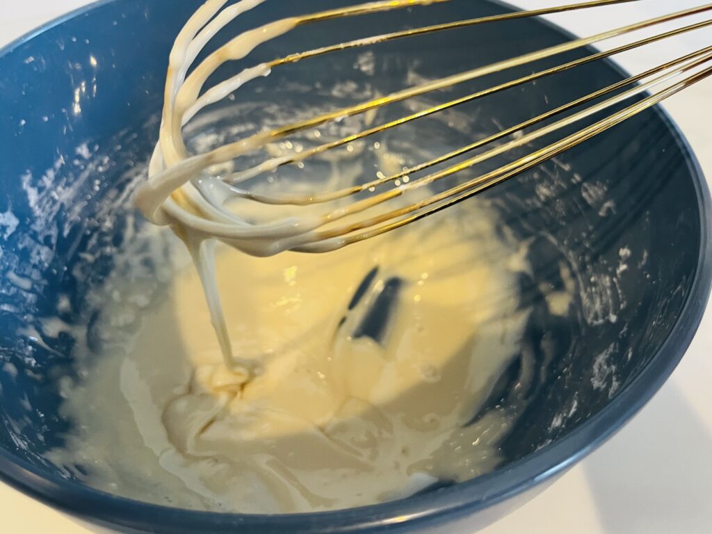 whisking icing in a mixing bowl.