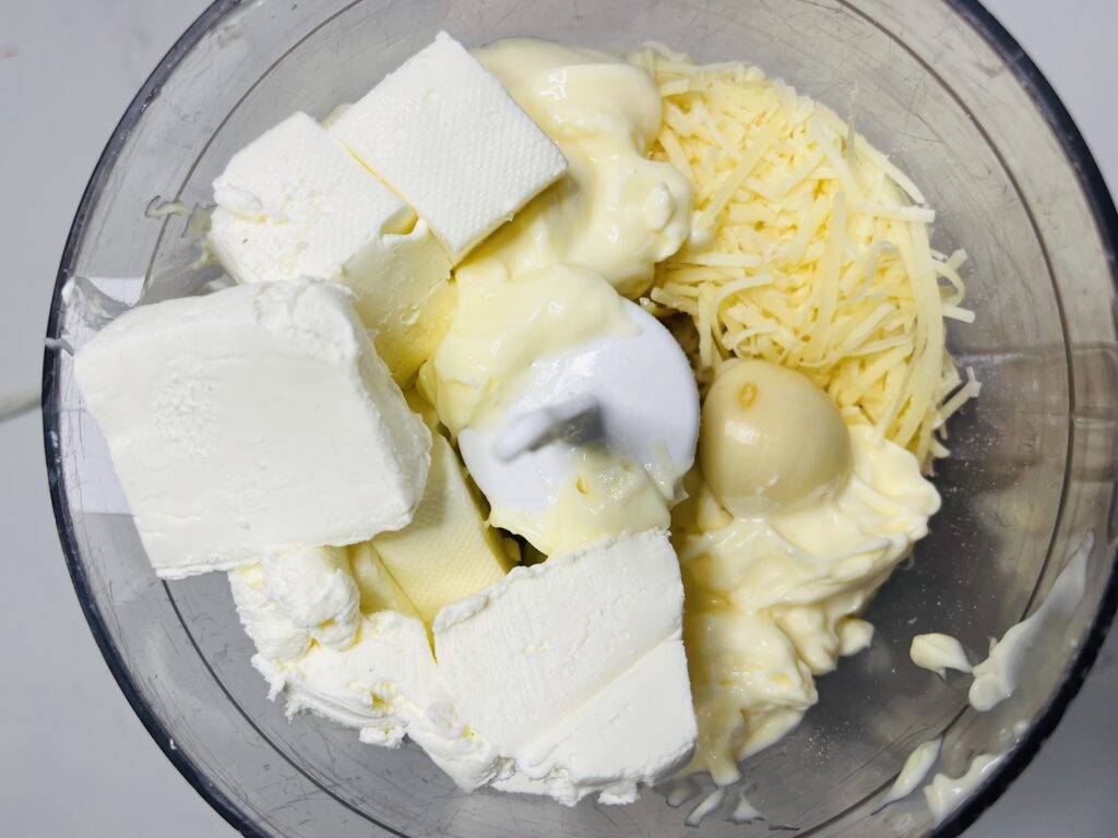 cream cheese, mayo, garlic clove, and parmesan cheese in a food processor.