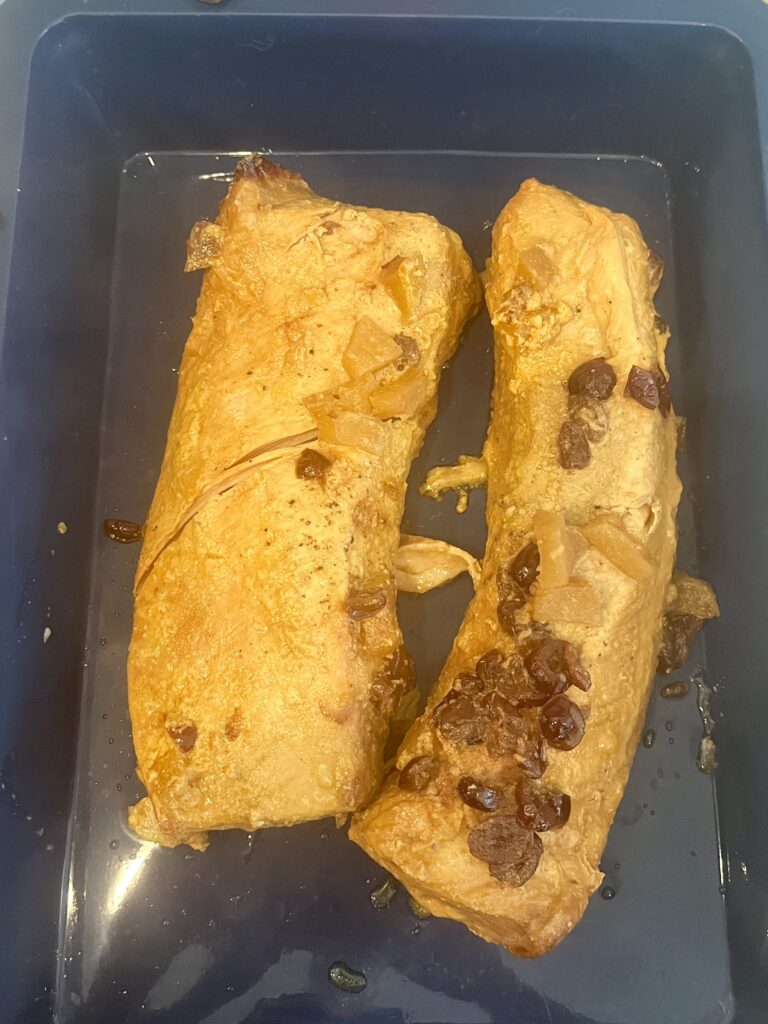 pork loin resting in a blue shallow pan on the counter.