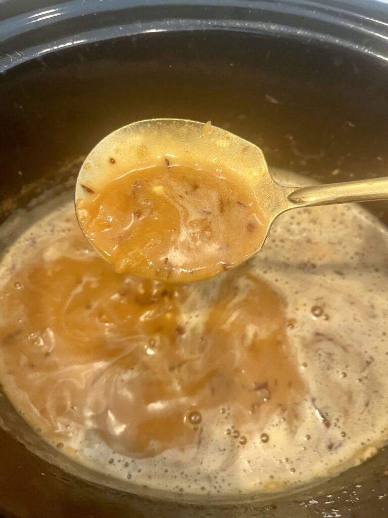 gravy in a slow cooker on a counter.