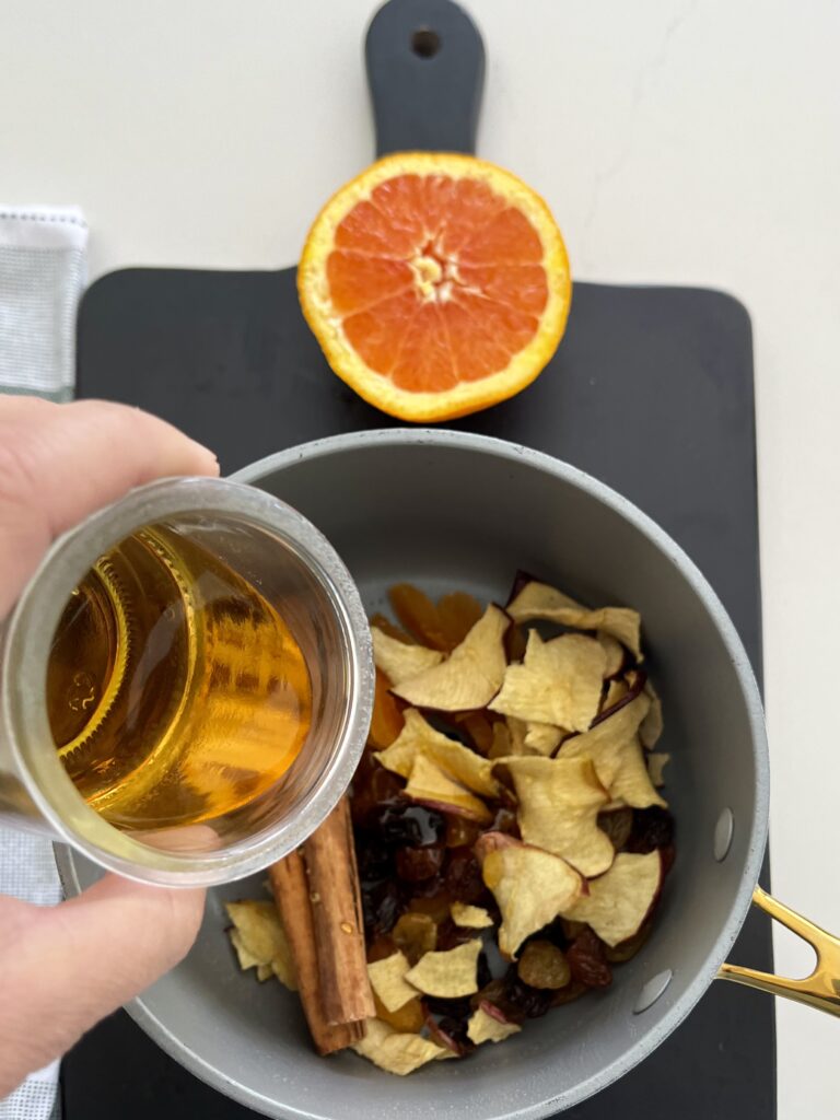 Dried fruit in a pot on a black cutting board on the counter.