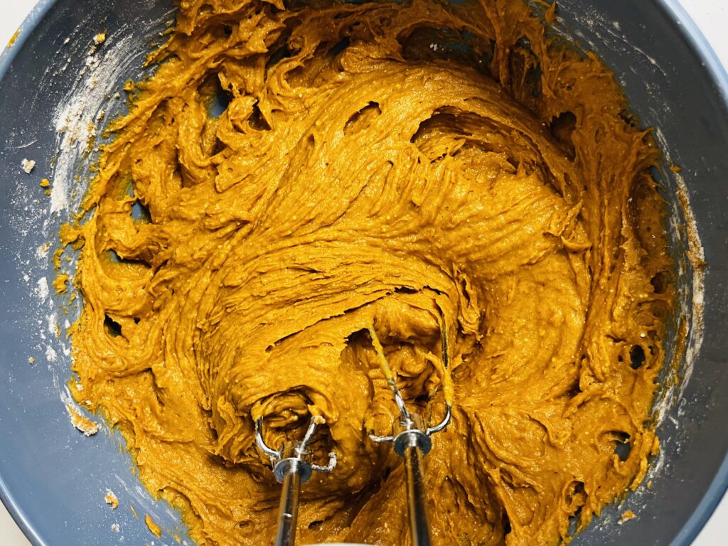 Mixed spice cake batter in a large blue bowl on the counter