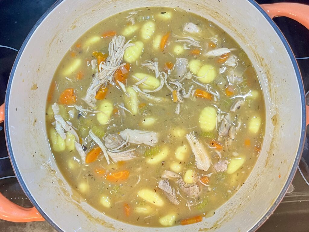 gnocchi in a pot with broth, chicken and vegetables