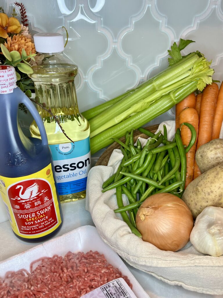 ground beef, soy sauce, celery, green beans, onion, garlic, potatoes and oil on a counter