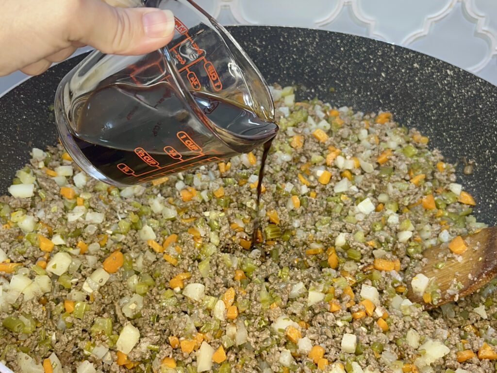 soy sauce bing poured into beef mixture