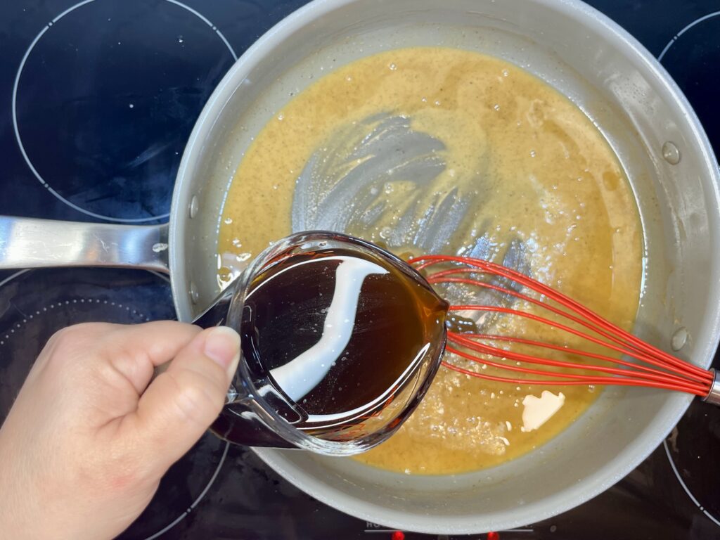 beef broth being poured into the roux