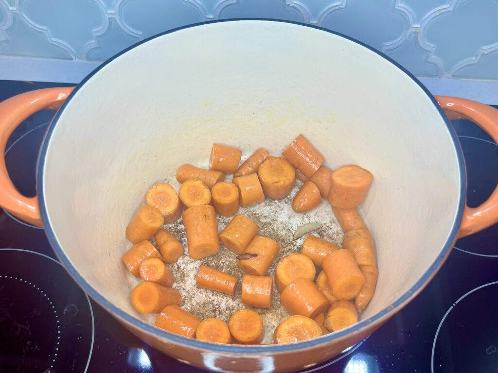 carrots being browned in a pot