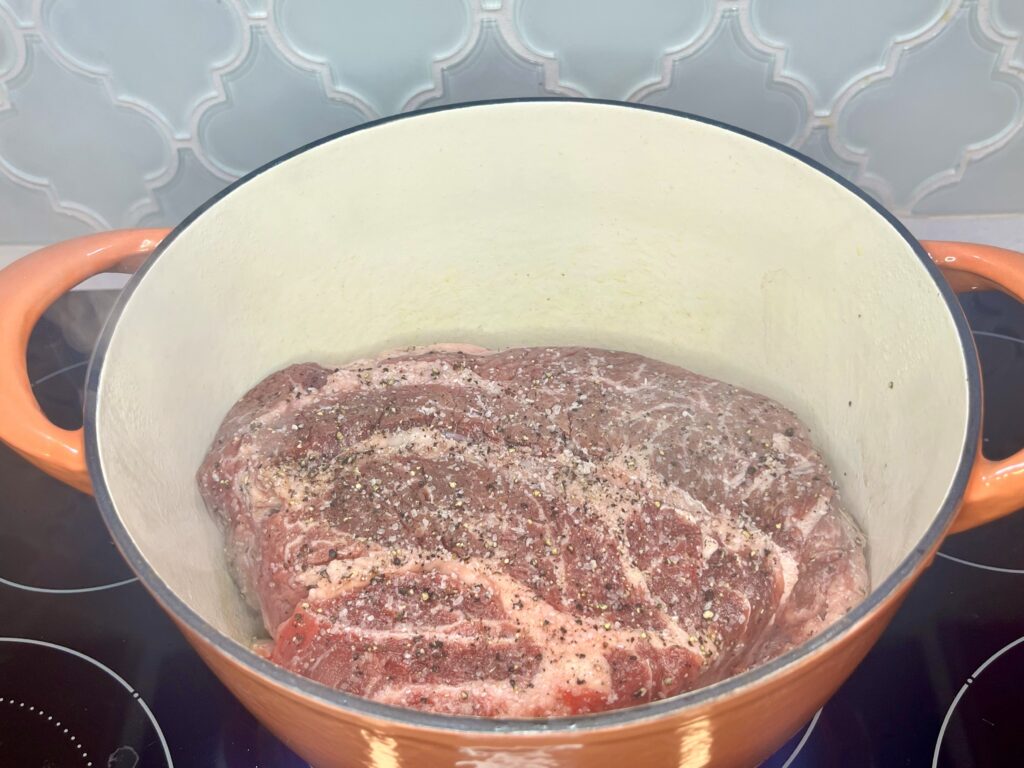 a chuck roast in a pot on a stove