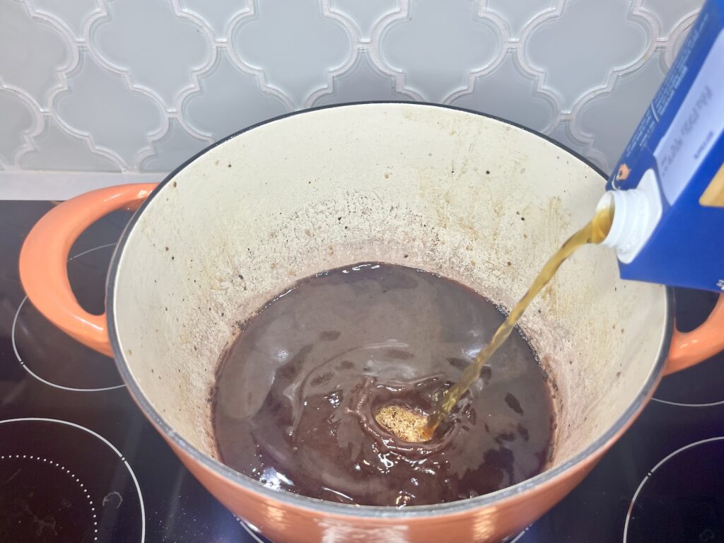 beef broth being added to a pot