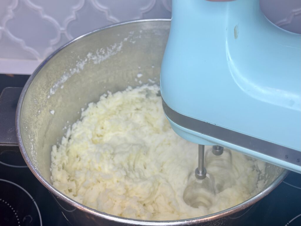 A pot of potatoes being whipped with an electric mixer
