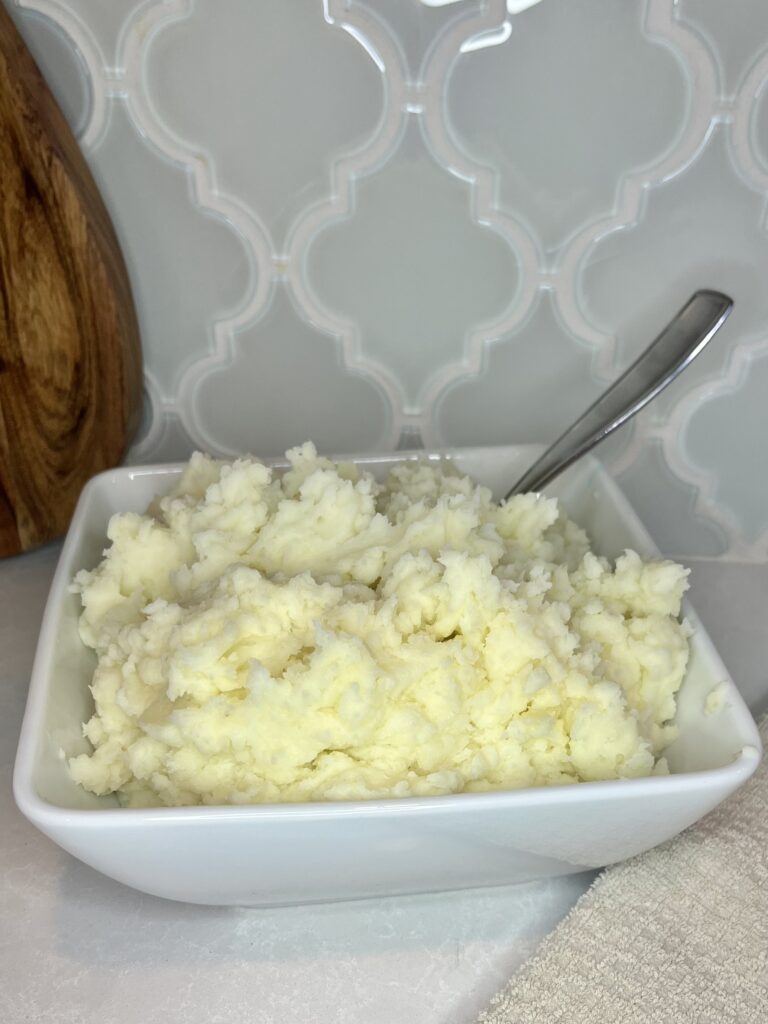 a bowl of cooked mashed potatoes on a counter