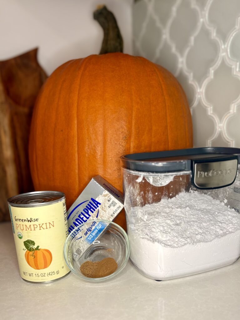 canned pumpkin, seasonings, cream cheese, and powdered sugar on a counter