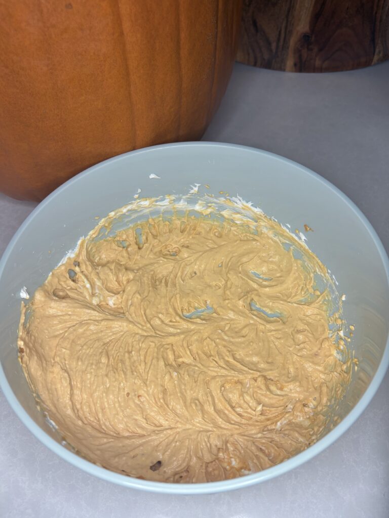 cream cheese and pumpkin mixed together in a bowl