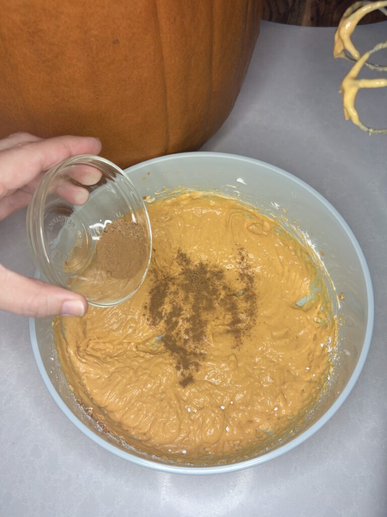 seasoning added to pumpkin mixture in a bowl