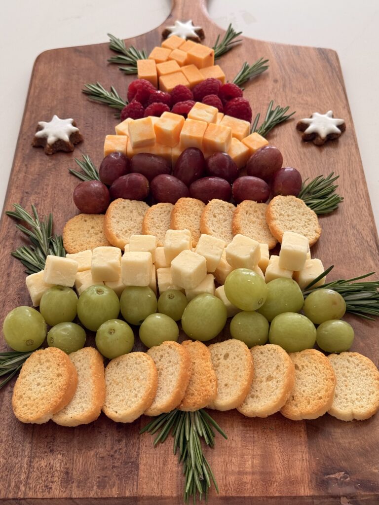 Holiday Cheese and Fruit Board on a brown board on the counter.