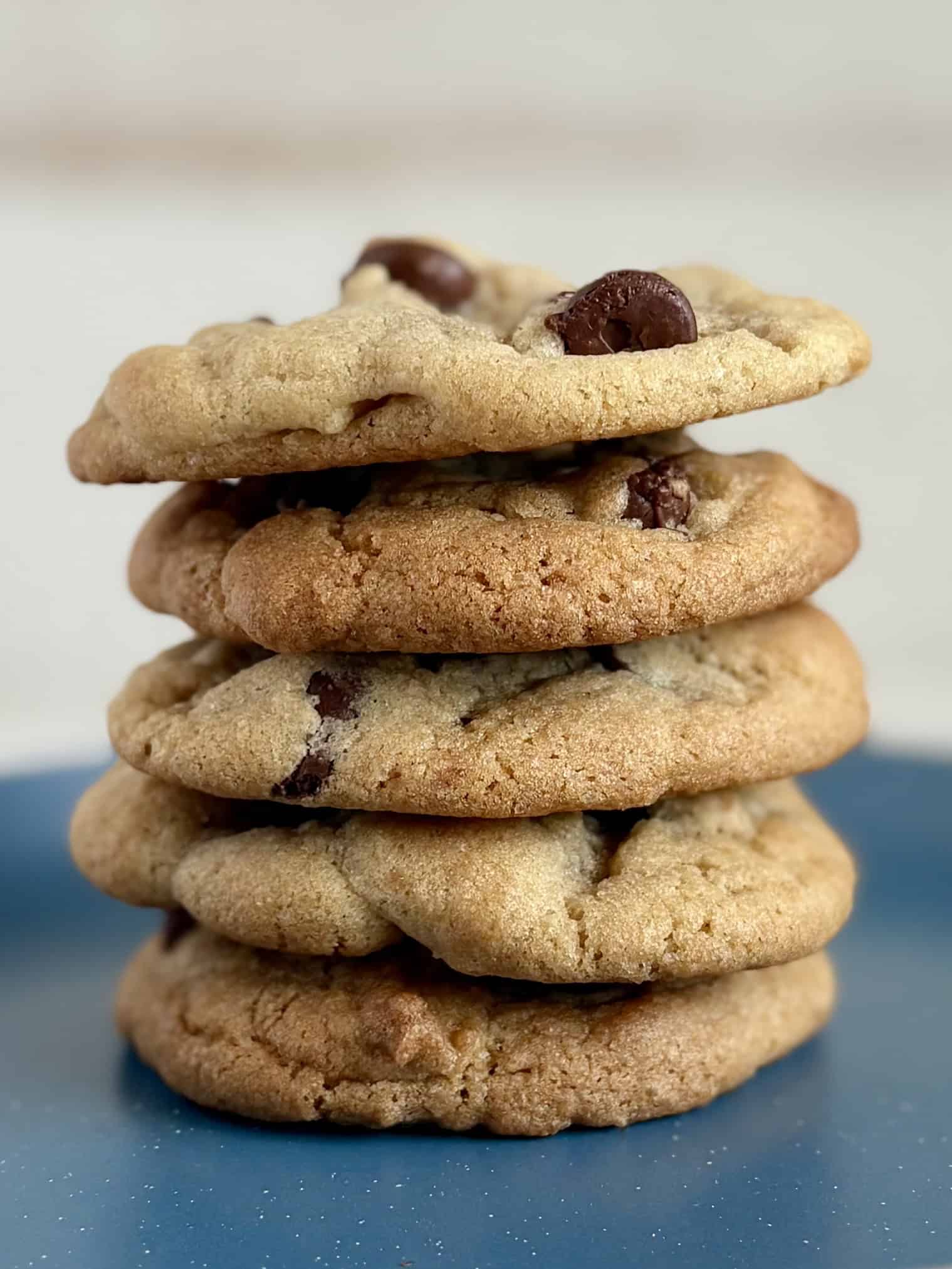 A stack of chocolate chip cookies on a blue plate
