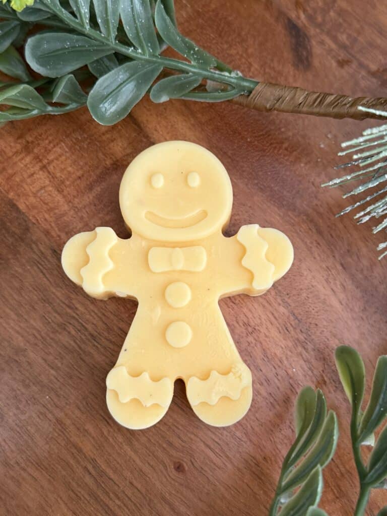 Gingerbread man, eggnog ice mold on a brown board found a big festive greenery.