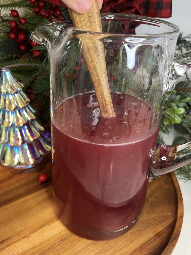 Juice and limeade in a pitcher on a brown tray on the counter