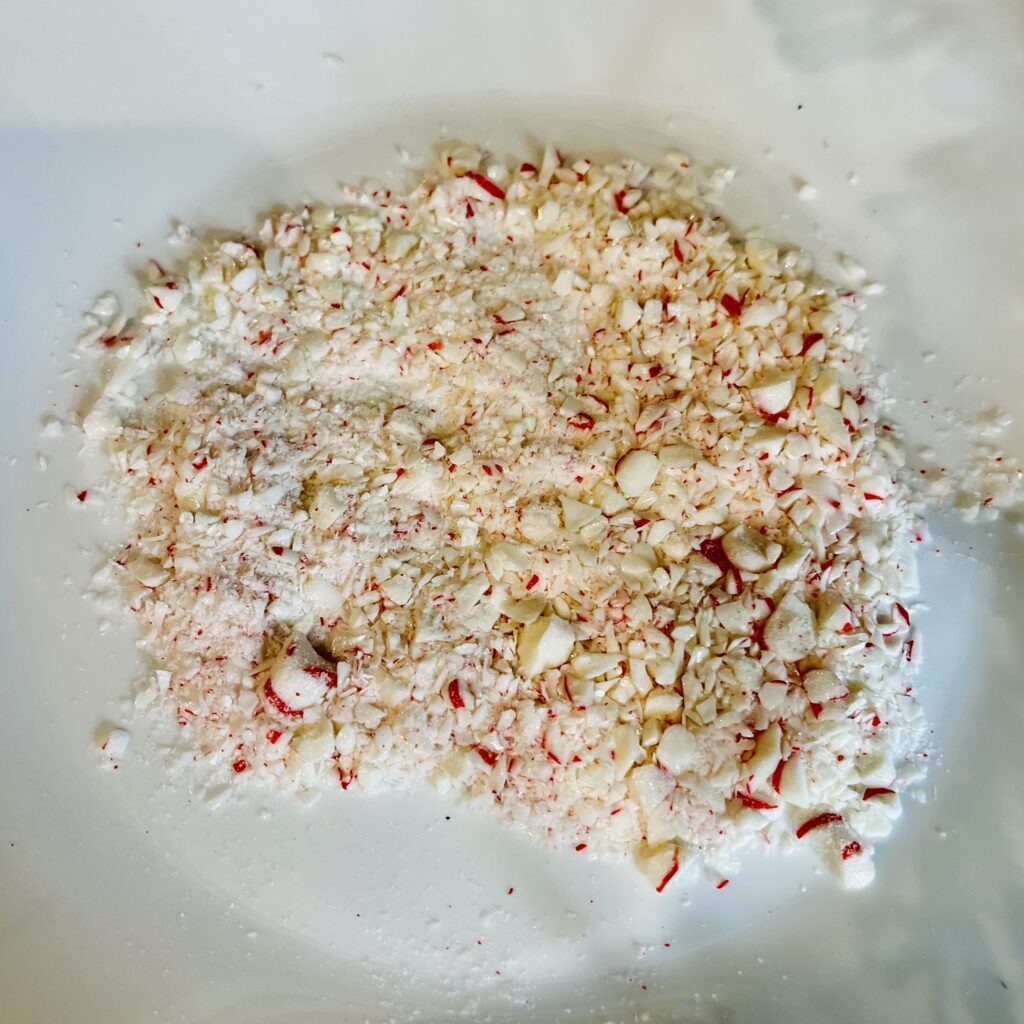 crushed peppermint candy on a white plate on the counter.