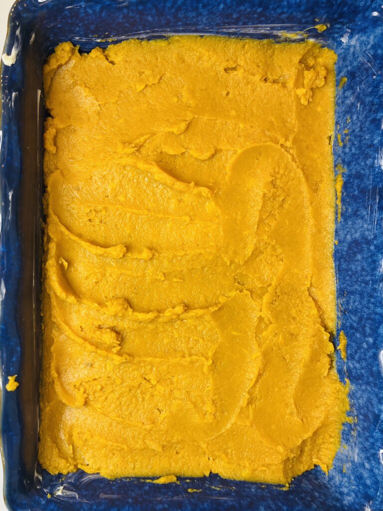 Mashed sweet potatoes in a blue casserole dish on the counter