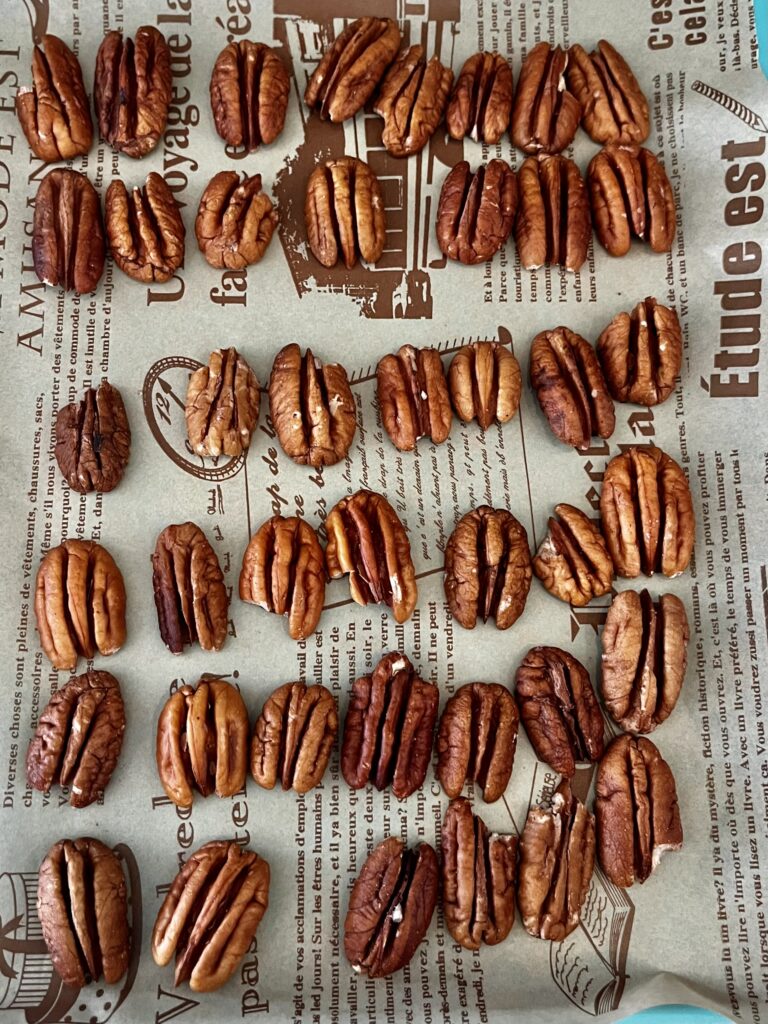 Lined up pecans on a line baking sheet on the top of the stove.