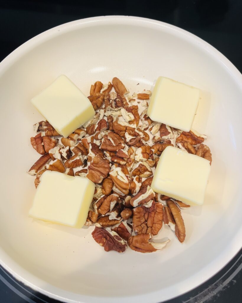 butter and pecans in a sauce pan on the stove.