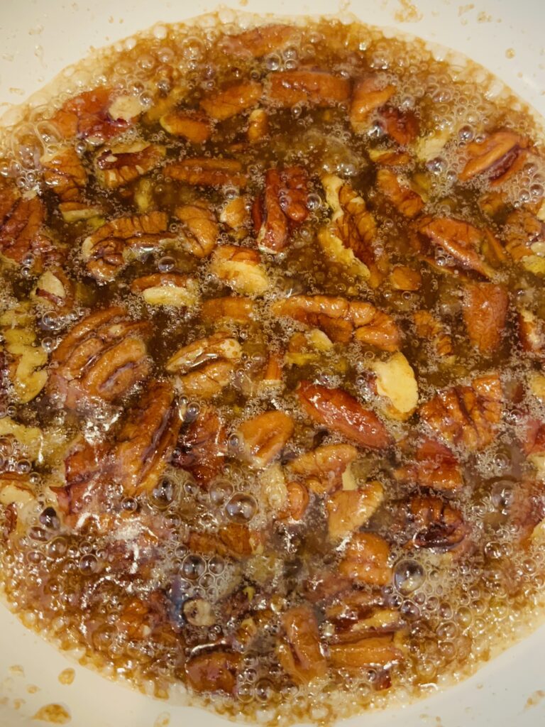 brown sugar, butter and pecans in a sauce pan on the stove