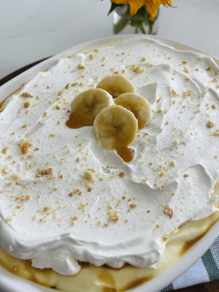 No bake banana caramel pudding in a white baking dish on the counter.