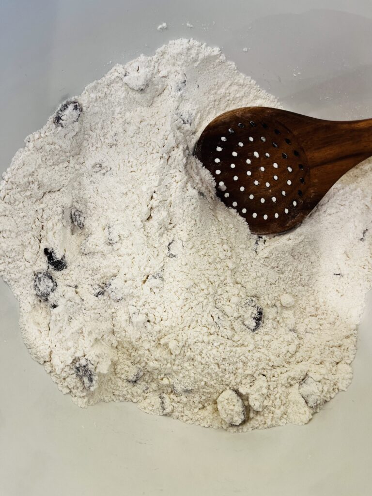 mixing dry ingredients in a large white bowl on the counter