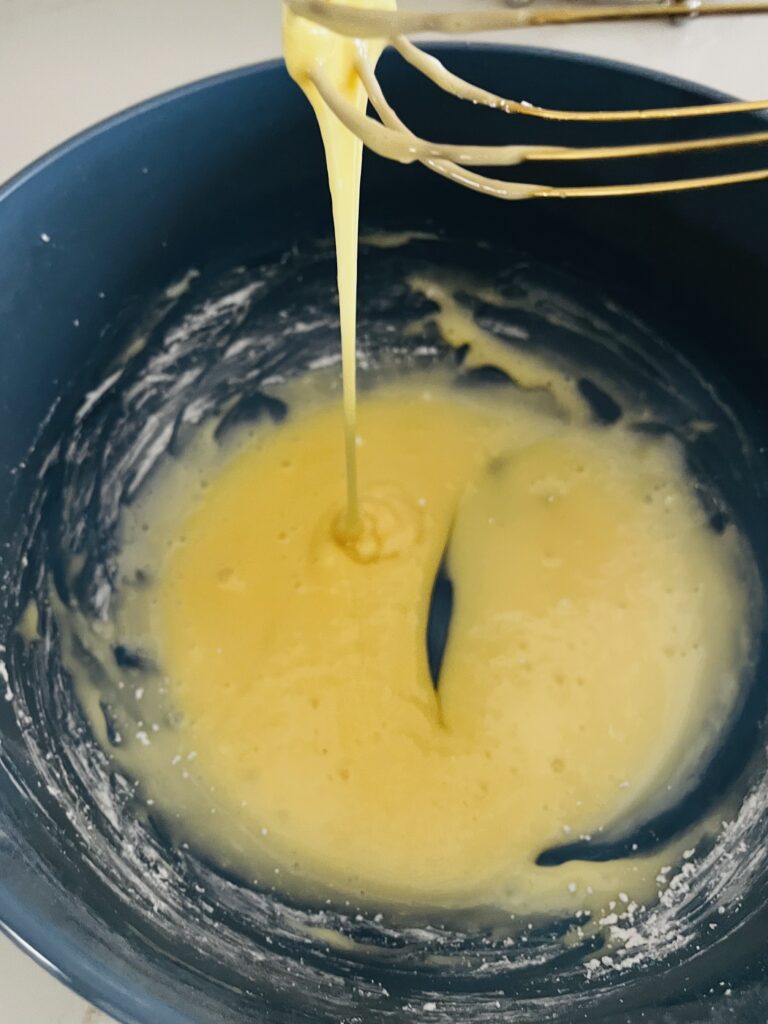 Whisked glaze in a large blue bowl on the counter