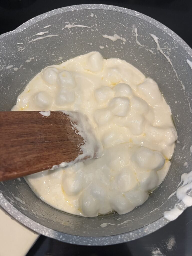 stirring melted marshmallows and butter in a pot on the stove