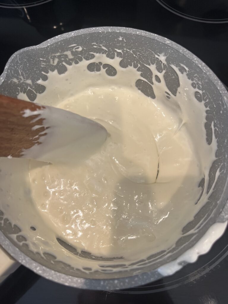 stirring melted marshmallows and butter in a pot on the stove