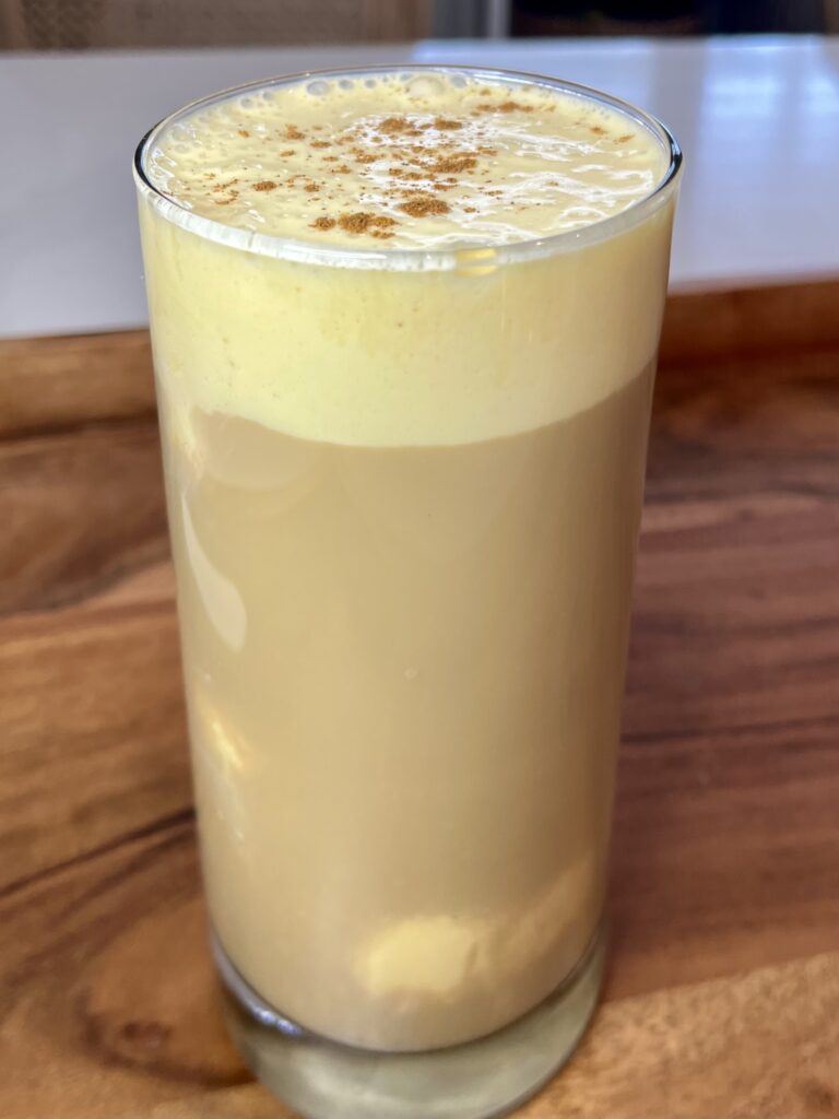 Iced eggnog coffee on a brown tray on the counter.