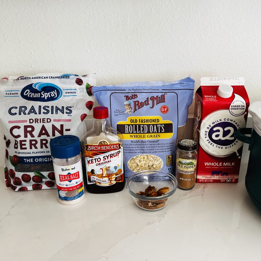 old fashioned rolled oats, dried cranberries, salt, cinnamon, milk, maple syrup-Birch Benders Keto sugar-free brand used and pecans in a bowl on the counter.