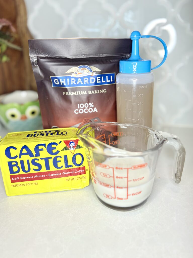 ground coffee, simple syrup, milk and cocoa on a counter