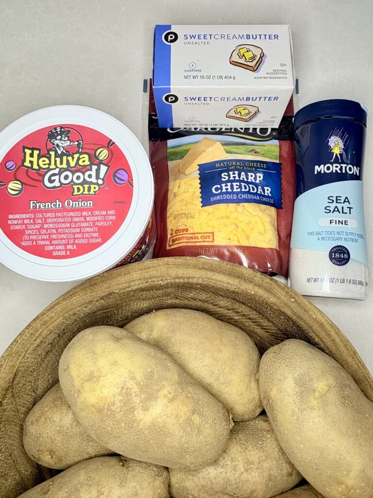 potatoes, French onion dip, butter, salt and shredded cheese on a counter 