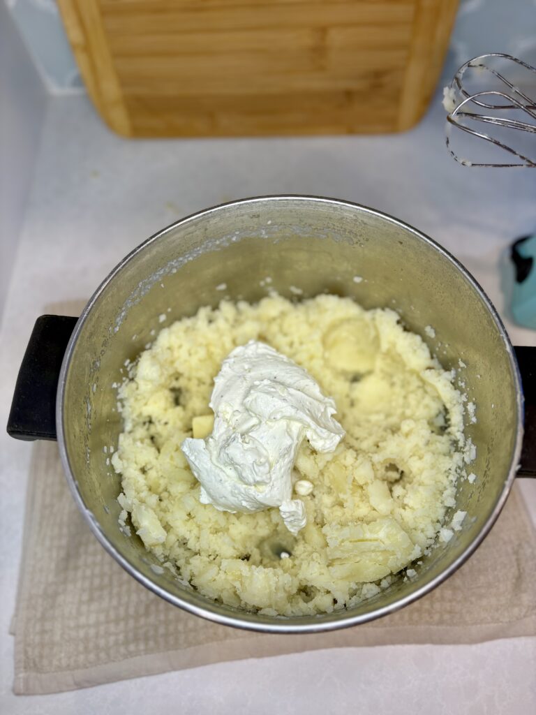 mashed potatoes in a pot with French onion dip, butter, and salt