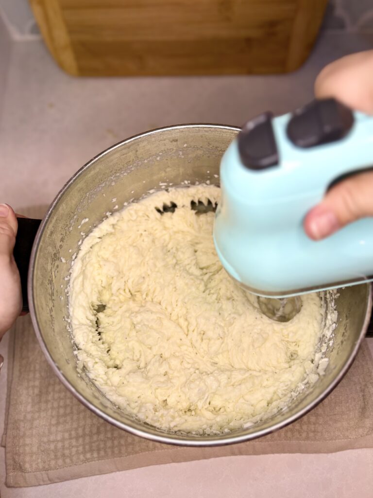 potatoes and dip being mixed with a hand mixer
