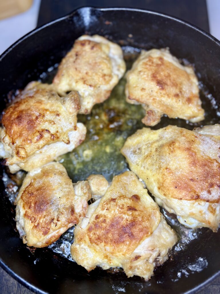 cooked chicken thighs in a cast iron skillet