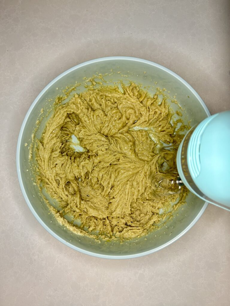 dough continuing to be mixed in a bowl with a hand mixer