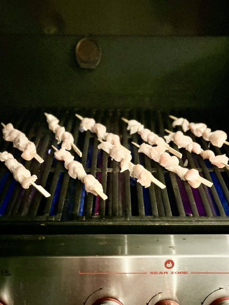 raw chicken breast skewers on a grill